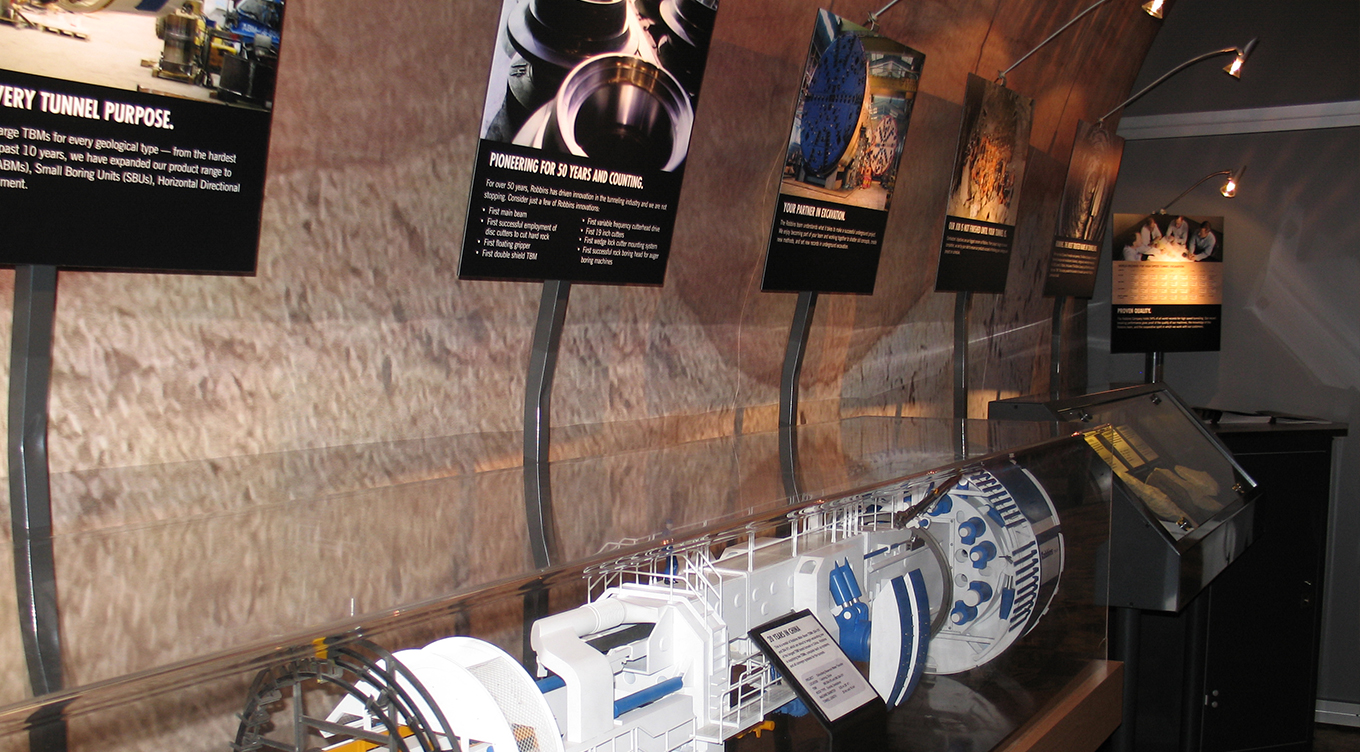 Tradeshow booth design with media displayed above models of tunnel boring machines