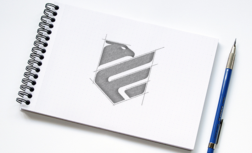 Image of logo sketch in notebook with pencil